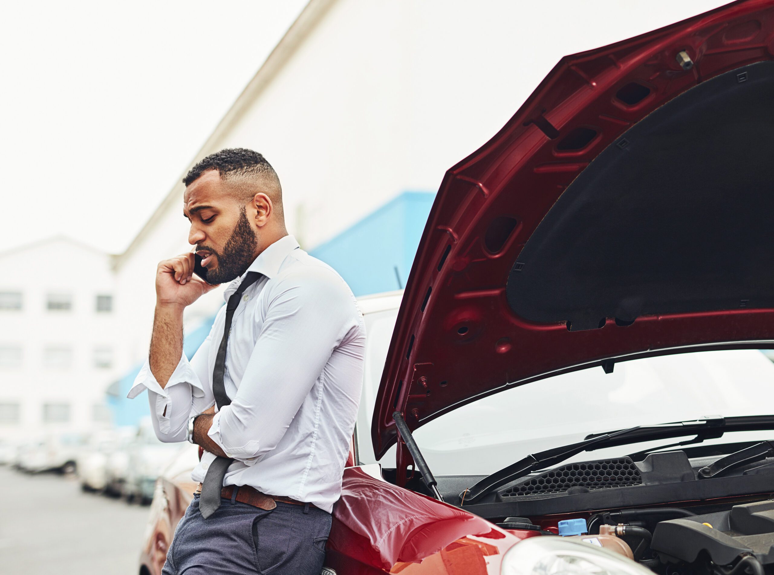 Shot of a man calling roadside assistance after breaking down. Minnesota Lemon Law.